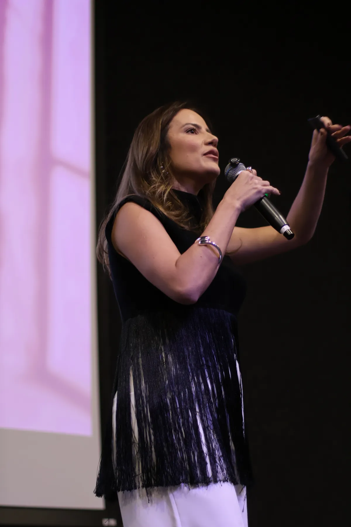 Lorena Macedo falando ao microfone durante um evento