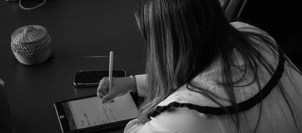 Profissional fazendo anotações em um tablet durante uma reunião