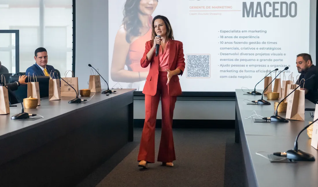 Lorena Macedo apresentando em uma sala de reunião